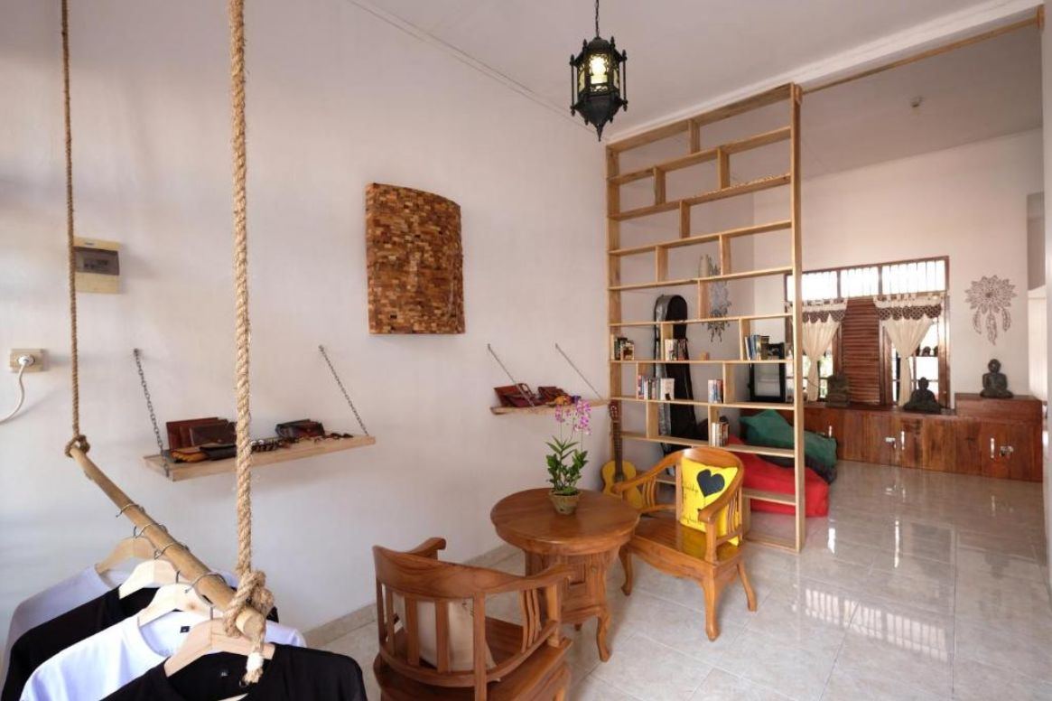 Indoor lounge with bookshelf, guitar and wooden chairs