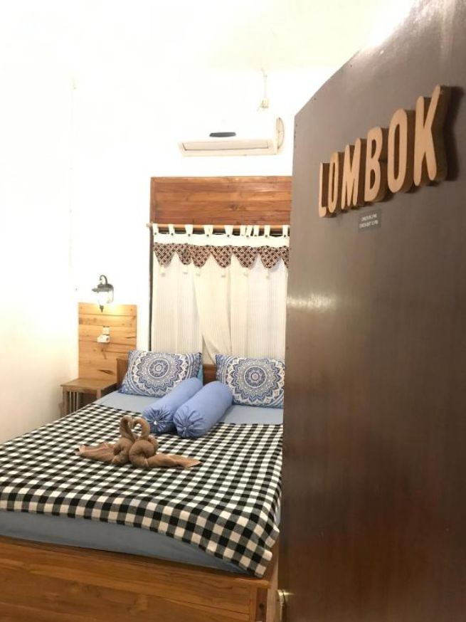 Queen Room Lombok with name sign on the door and checkered quilt