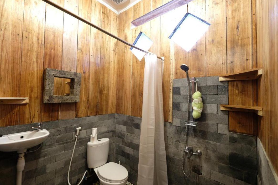 Shared bathroom with basalt stone and natural wood walls
