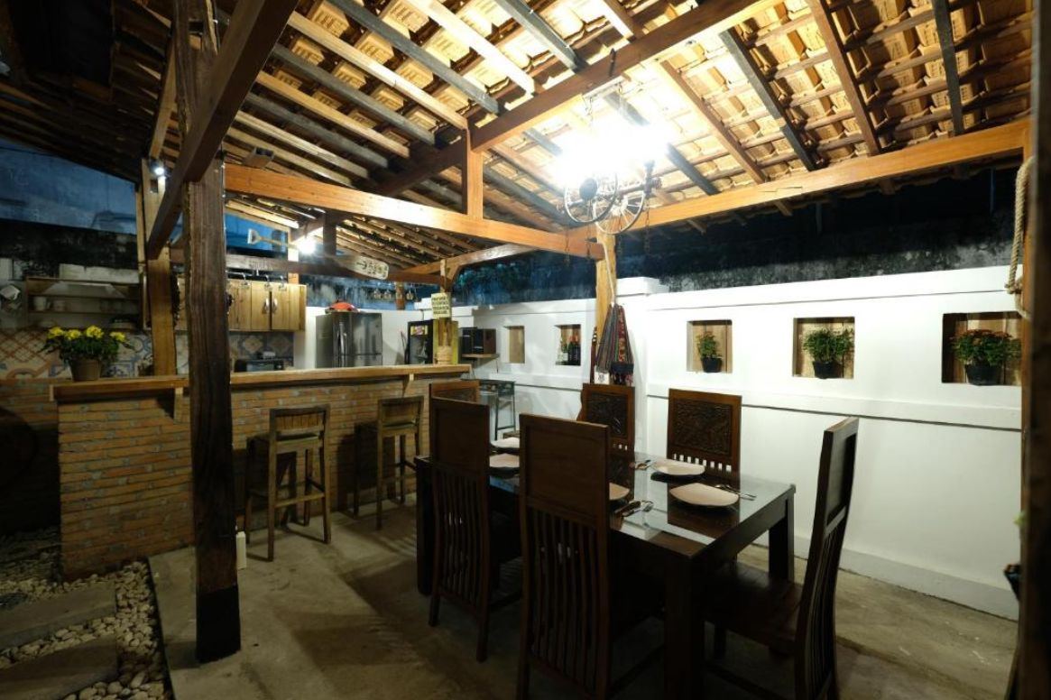 Fully equipped shared kitchen with brick counter and carved wooden dining table